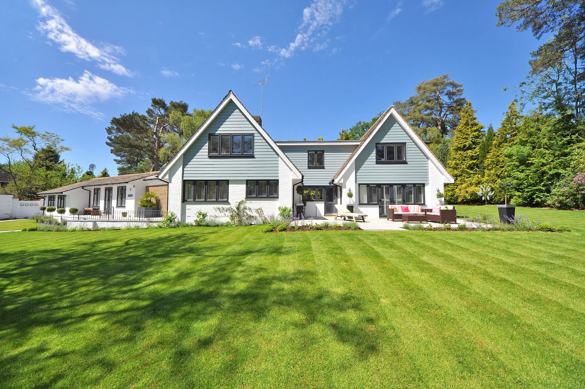 A freshly maintained green lawn stretching toward a bright residential home